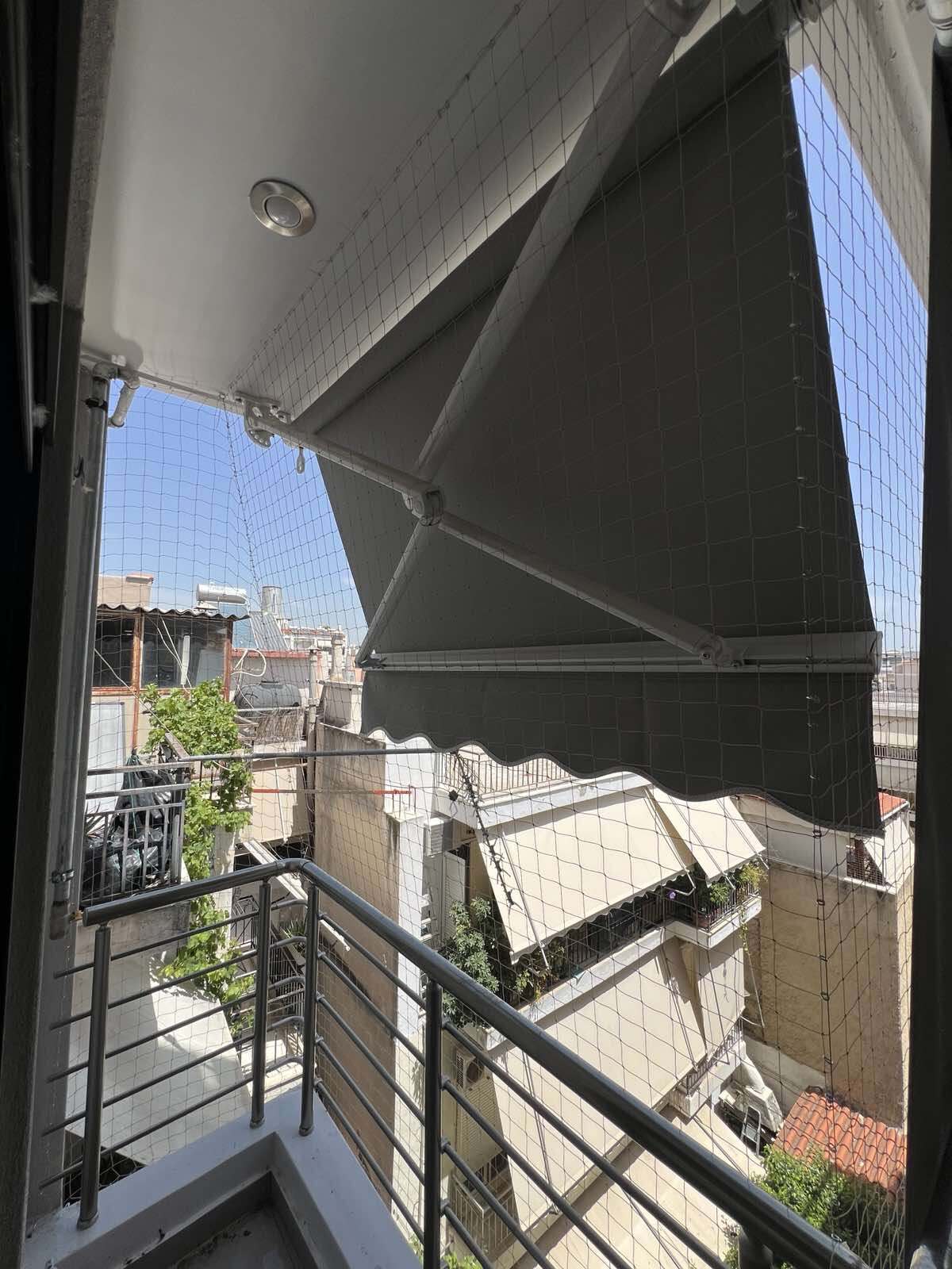 Συνεργείο εγκαθιστά δίχτυ προστασίας μπαλκονιού από περιστέρια.