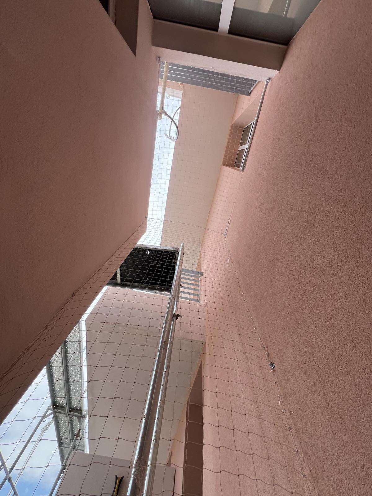 Επαγγελματική τοποθέτηση διάφανου διχτυού σε φωταγωγό πολυκατοικίας