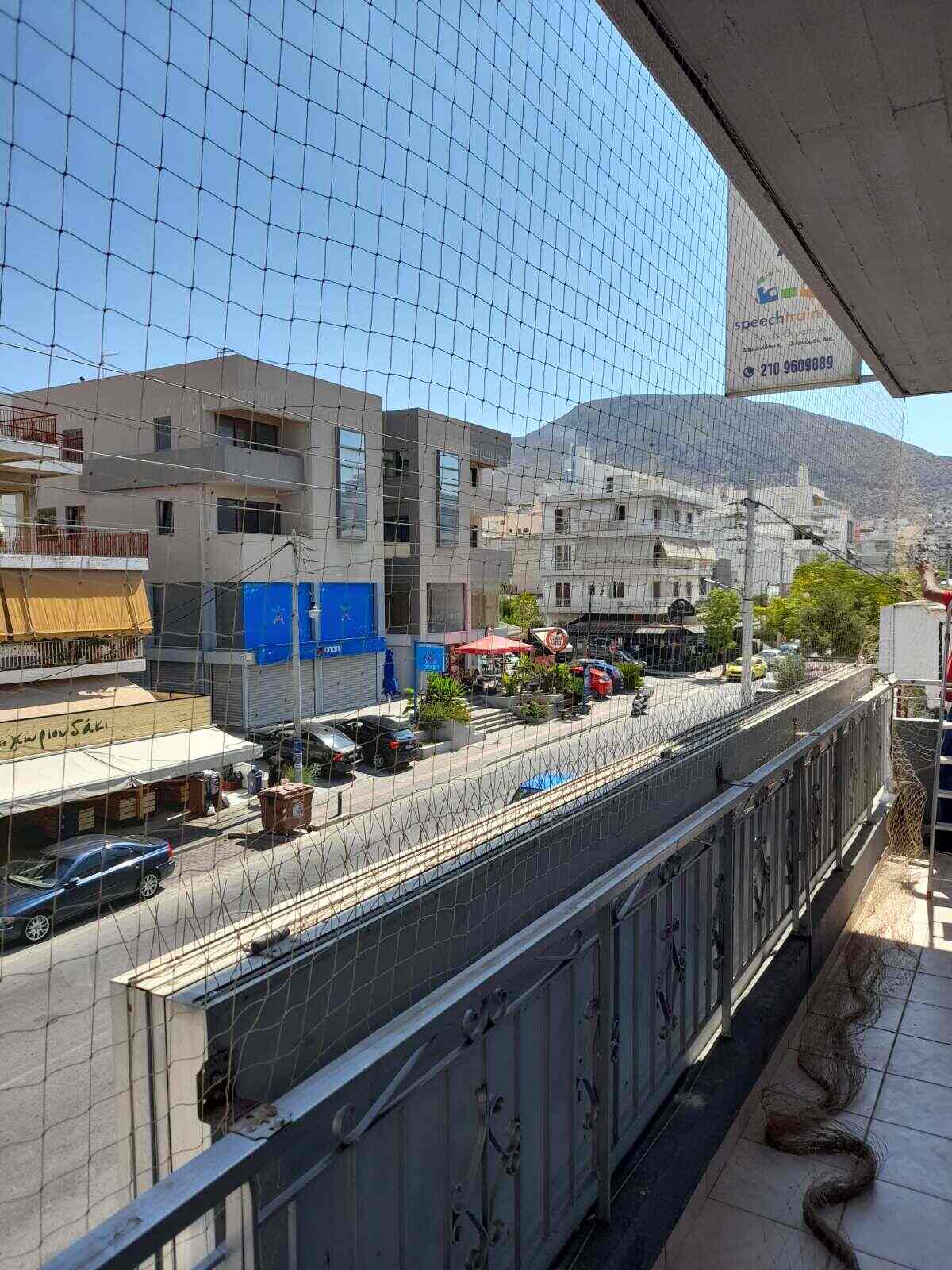 Τοποθέτηση διχτυού απώθησης περιστεριών σε επαγγελματικό μπαλκόνι γραφείων για πρόληψη μικροβίων και προστασία του προσωπικού.